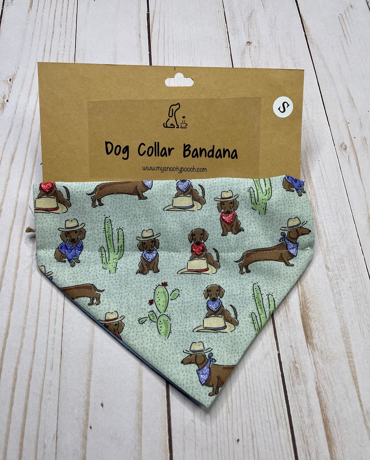 a green dog bandanna with dachshunds in hats and cactus 